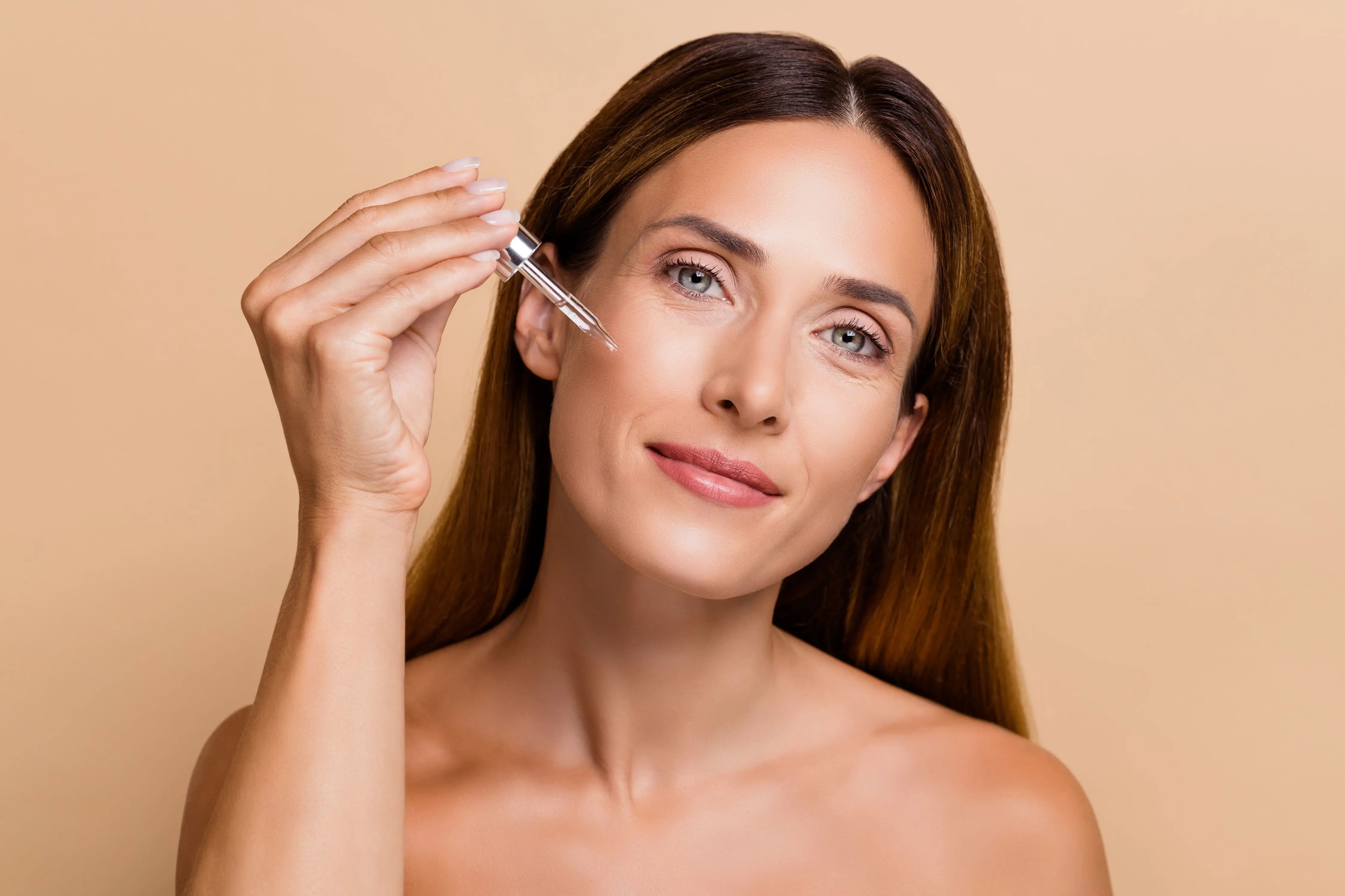 Donna che usa un siero viso per esfoliare la pelle e rimuovere le cellule morte